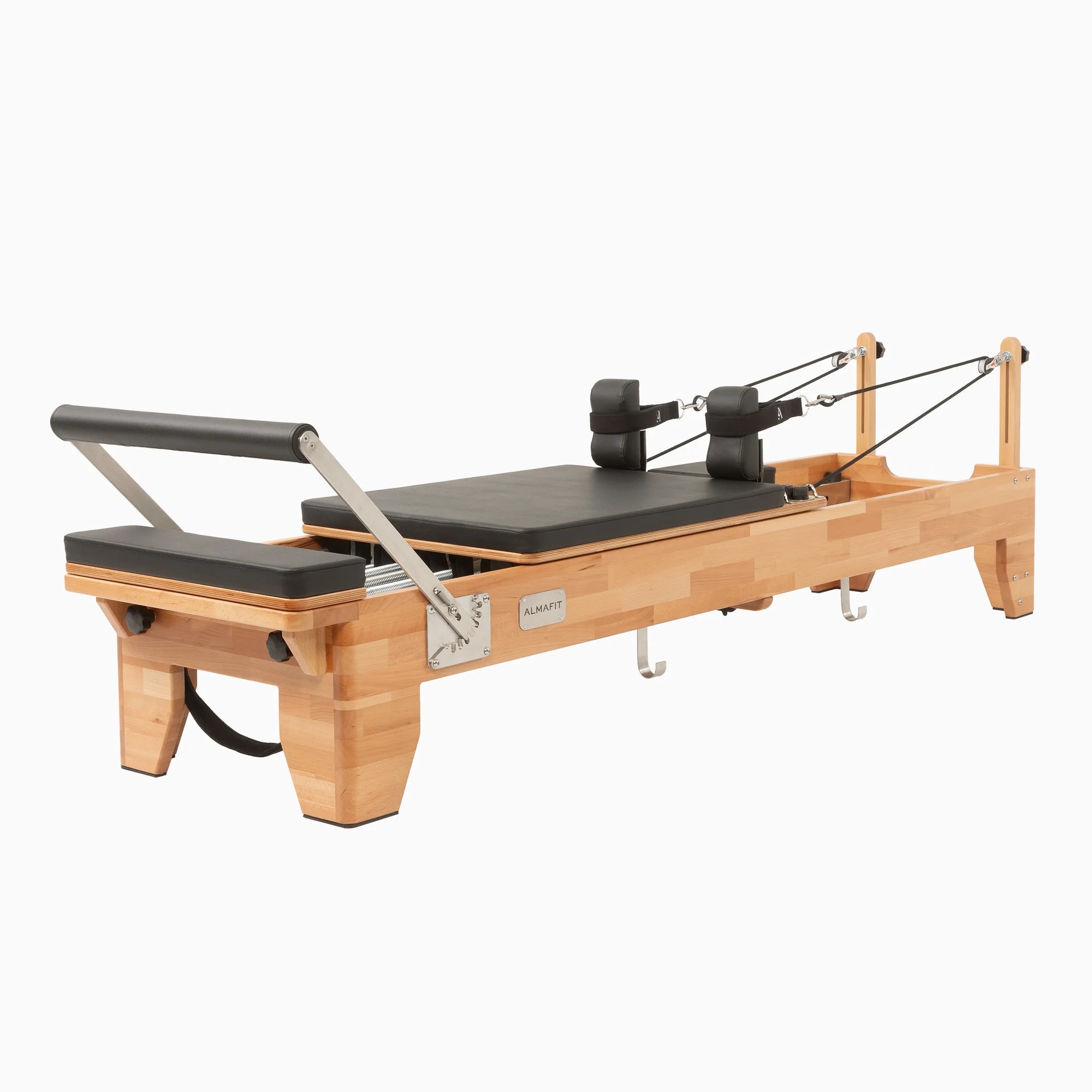 Almafit Elysium Pilates reformer machine made of beech wood with stainless-steel footbar and black padded upholstery, designed for fitness and wellness exercises.
